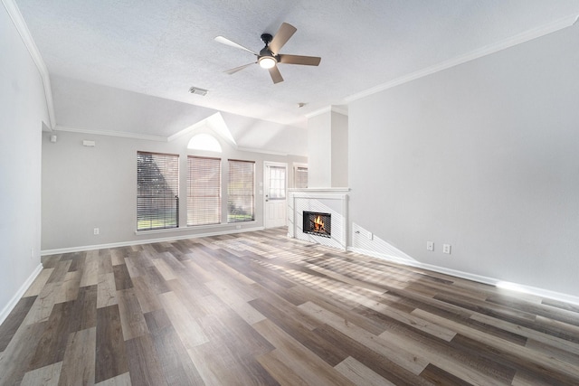 unfurnished living room with a textured ceiling, vaulted ceiling, ceiling fan, hardwood / wood-style flooring, and a tiled fireplace