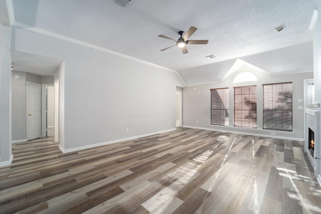 unfurnished living room featuring ceiling fan, dark hardwood / wood-style floors, a textured ceiling, vaulted ceiling, and ornamental molding