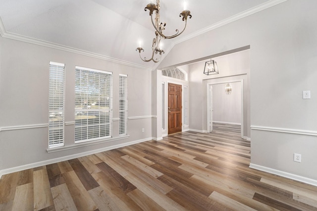 unfurnished dining area featuring hardwood / wood-style floors, a notable chandelier, crown molding, and vaulted ceiling