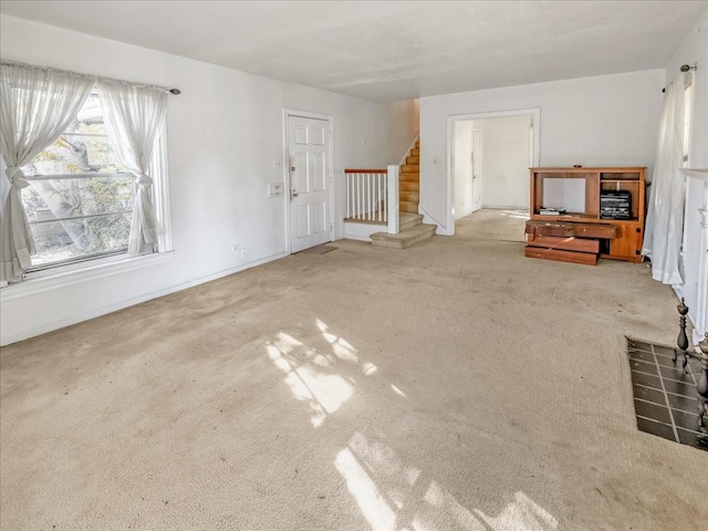 unfurnished living room with light colored carpet