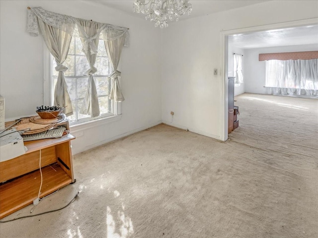 unfurnished room with a notable chandelier and light colored carpet