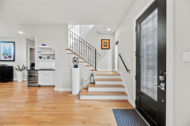 entrance foyer featuring wine cooler and light hardwood / wood-style floors