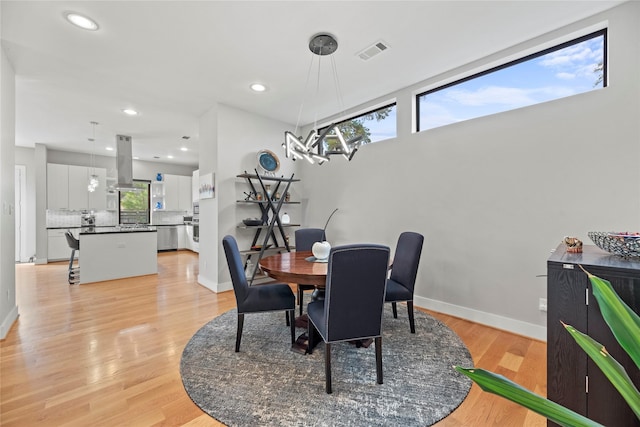 dining area with light wood-type flooring and plenty of natural light