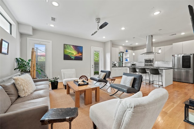 living room with ceiling fan and light hardwood / wood-style floors