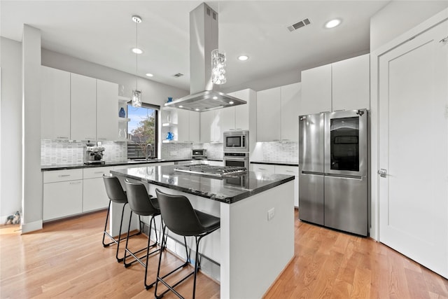 kitchen with a center island, sink, white cabinetry, appliances with stainless steel finishes, and island range hood