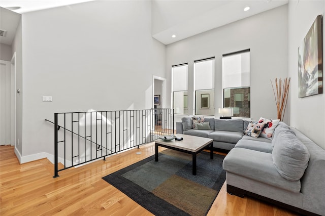 living room with a towering ceiling and hardwood / wood-style floors