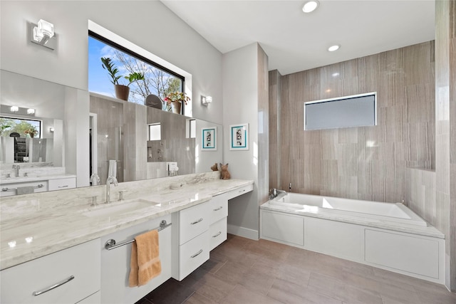 bathroom with vanity and a relaxing tiled tub