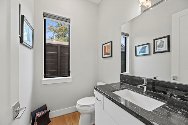 bathroom with toilet, vanity, and hardwood / wood-style flooring