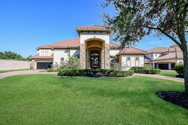 mediterranean / spanish house with a front yard and a garage