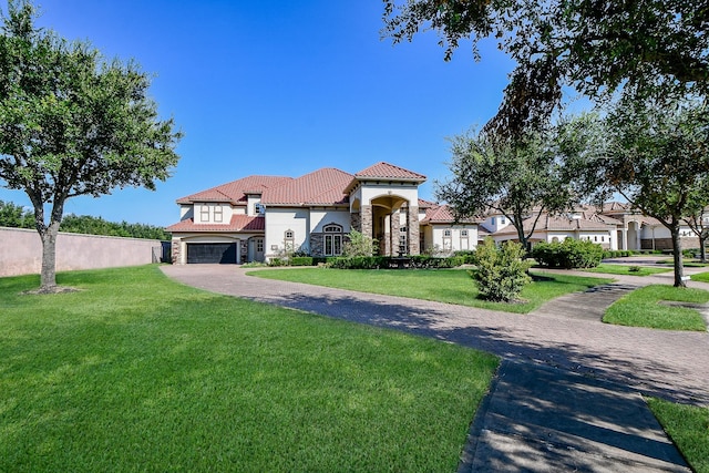 mediterranean / spanish home featuring a garage and a front lawn