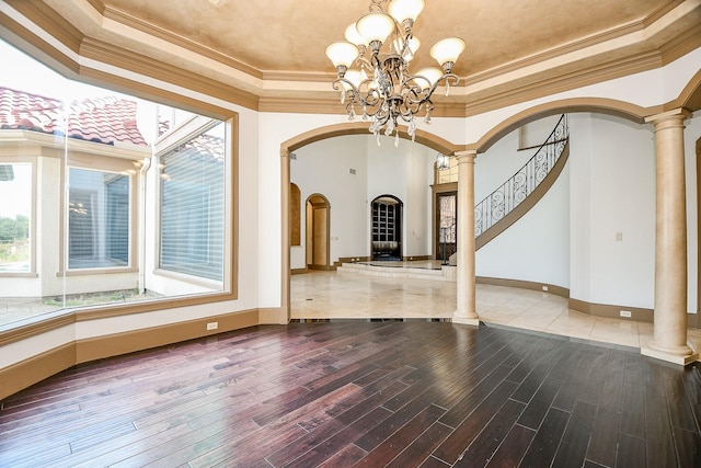 interior space featuring ornate columns, crown molding, hardwood / wood-style floors, and an inviting chandelier