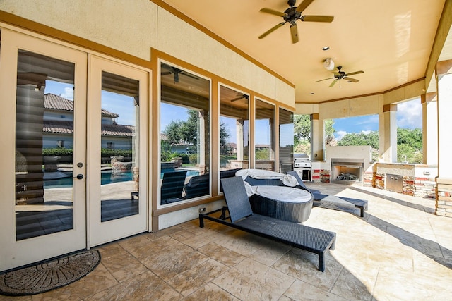 sunroom with french doors, exterior fireplace, and ceiling fan