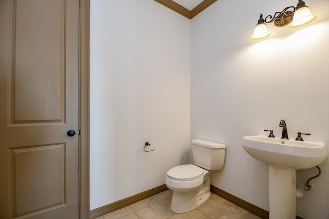 bathroom with sink, toilet, crown molding, and tile patterned floors