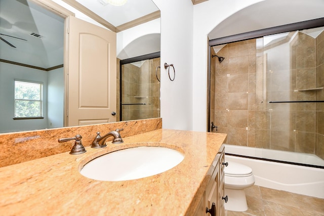 full bathroom with tile patterned floors, bath / shower combo with glass door, vanity, ceiling fan, and toilet