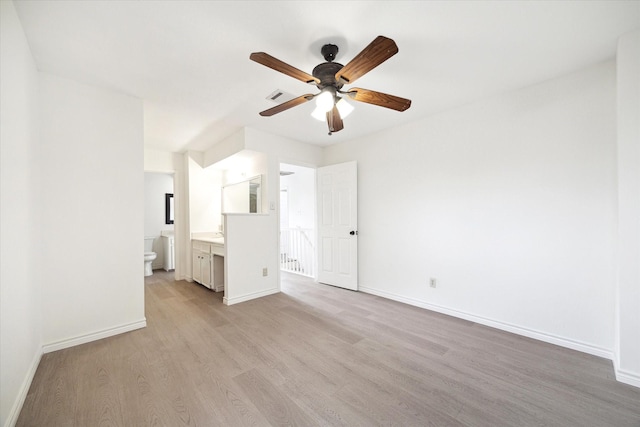 unfurnished bedroom with light wood-type flooring, connected bathroom, and ceiling fan