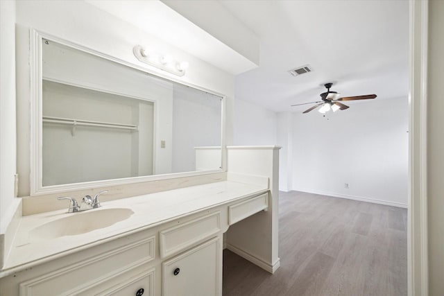 bathroom with wood-type flooring, vanity, and ceiling fan