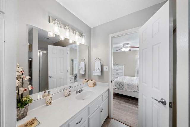 bathroom featuring ceiling fan, hardwood / wood-style floors, vanity, and walk in shower