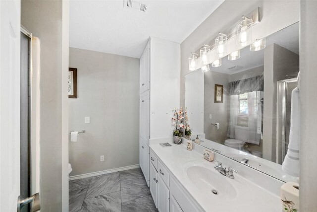 bathroom with vanity, toilet, and a shower with shower door