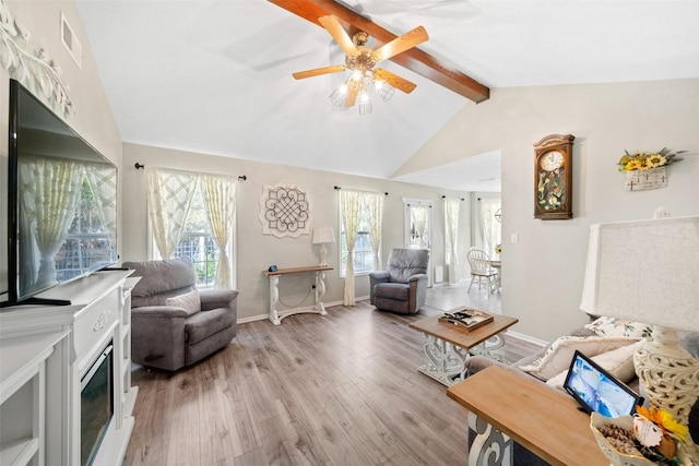 living room with ceiling fan, lofted ceiling with beams, light hardwood / wood-style floors, and a wealth of natural light