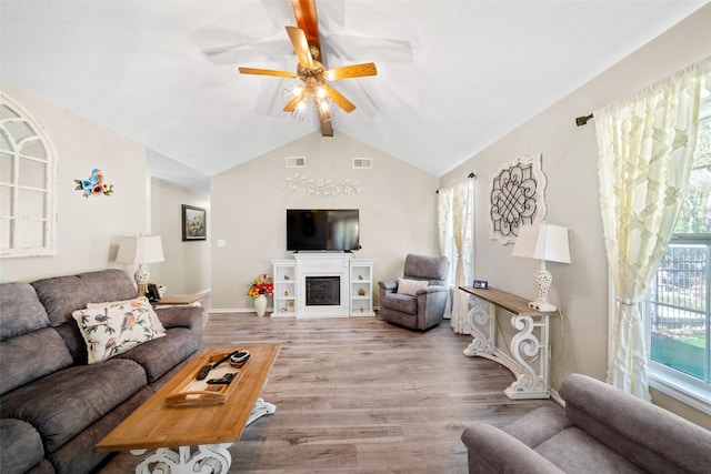 living room with vaulted ceiling with beams, a healthy amount of sunlight, ceiling fan, and light hardwood / wood-style floors