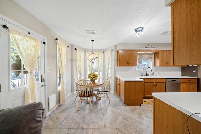 kitchen with stainless steel dishwasher, pendant lighting, and sink