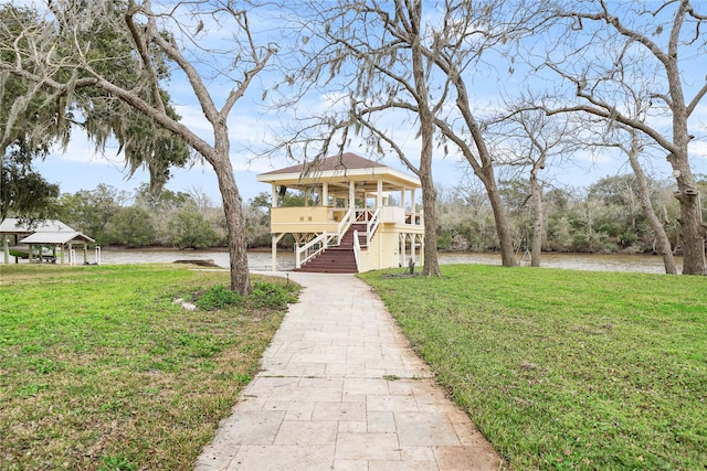 view of front of house with a water view and a front lawn