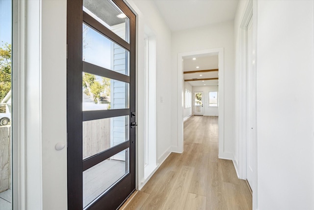 interior space featuring beam ceiling and light wood-type flooring