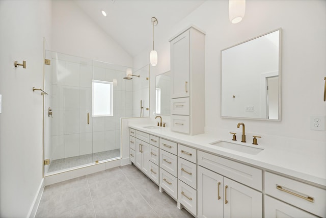 bathroom with lofted ceiling, vanity, a shower with shower door, and tile patterned floors