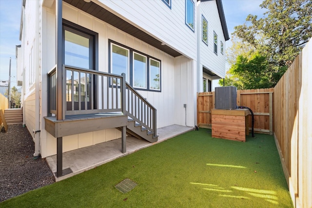 exterior space featuring central AC and a lawn