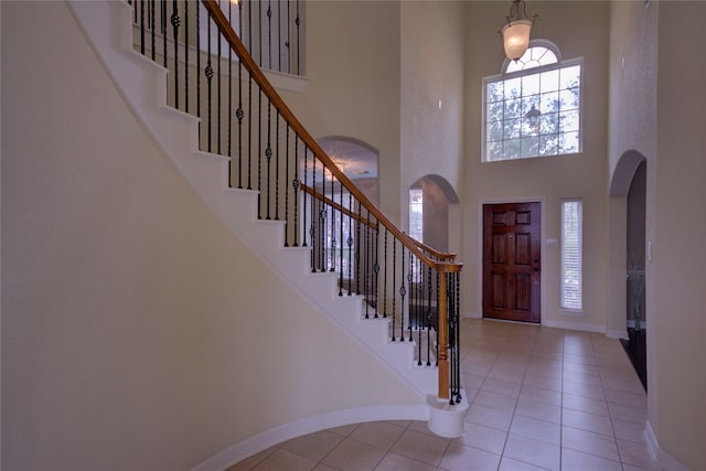 foyer featuring a towering ceiling and light tile patterned floors