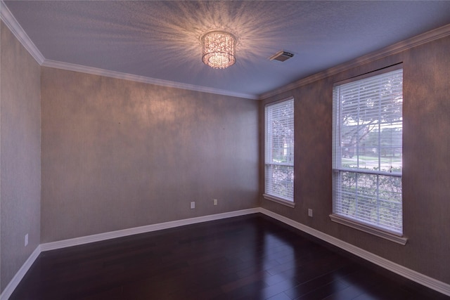 empty room with dark wood-type flooring, an inviting chandelier, and crown molding