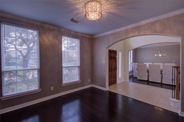 interior space with ornamental molding, a chandelier, and hardwood / wood-style floors