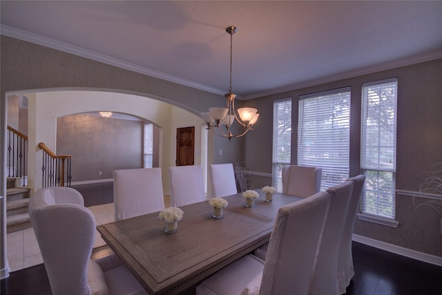 dining space featuring dark hardwood / wood-style flooring, an inviting chandelier, and crown molding