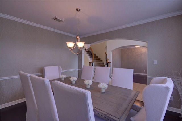 dining room with ornamental molding and a chandelier