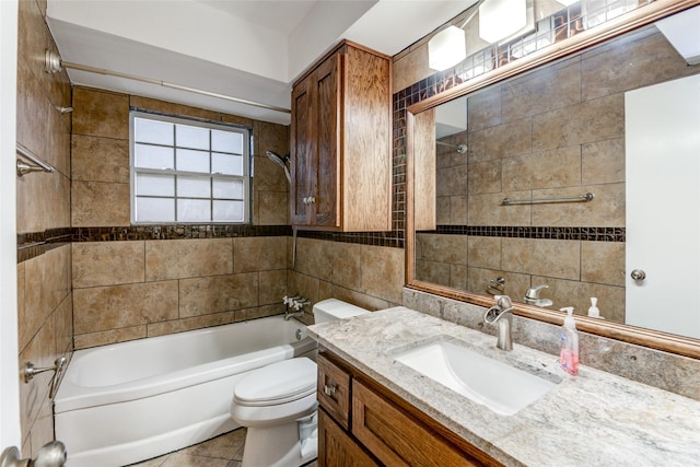 full bathroom featuring vanity, tile patterned floors, tiled shower / bath combo, toilet, and tile walls