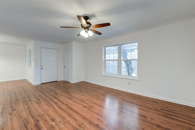 empty room with baseboards, wood finished floors, a ceiling fan, and crown molding