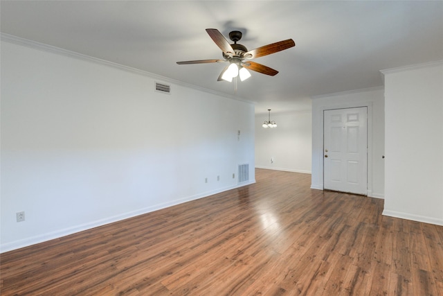 empty room featuring dark hardwood / wood-style floors, crown molding, and ceiling fan with notable chandelier