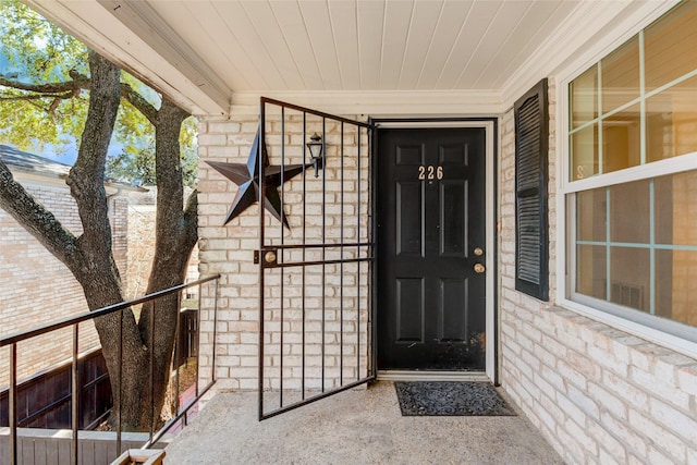 view of exterior entry featuring brick siding