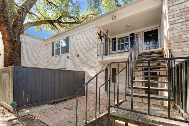 entrance to property with brick siding and fence