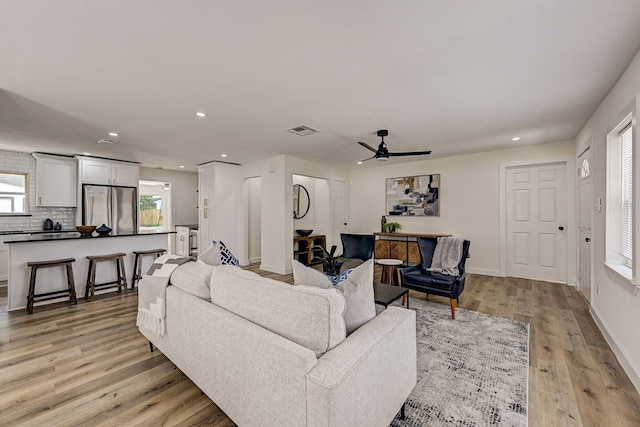 living room featuring ceiling fan and light wood-type flooring