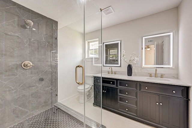 bathroom with tile patterned flooring, vanity, toilet, and a shower with shower door