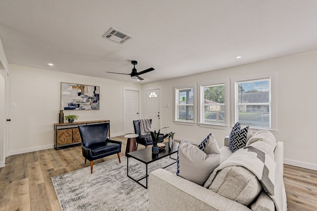 living room featuring light hardwood / wood-style floors and ceiling fan