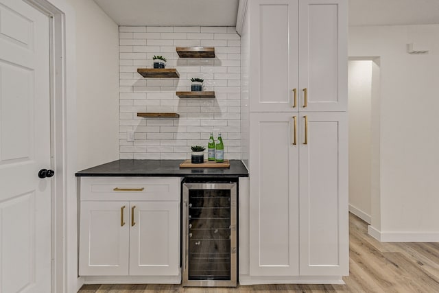 bar with white cabinets, light wood-type flooring, backsplash, and wine cooler