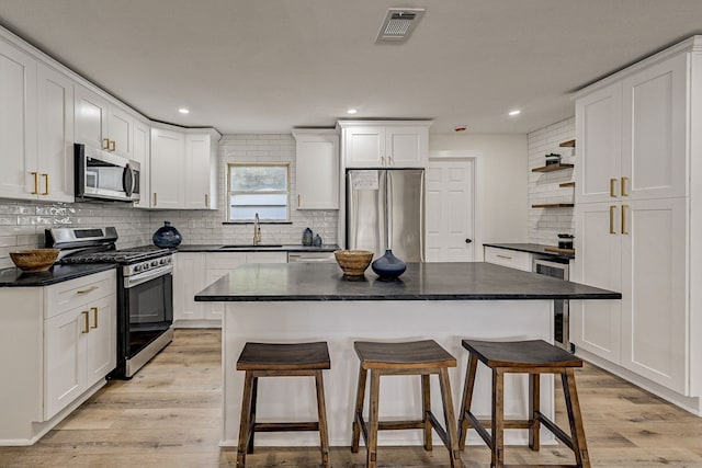 kitchen with stainless steel appliances, white cabinetry, and sink