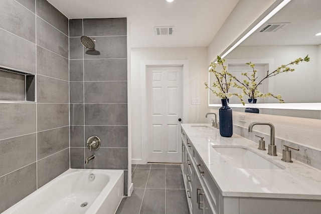 bathroom featuring tile patterned flooring, vanity, and tiled shower / bath