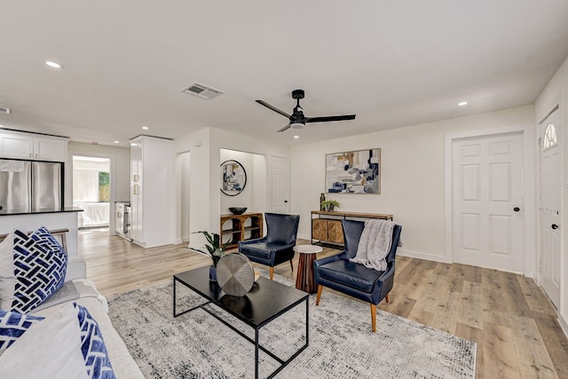 living area featuring recessed lighting, visible vents, light wood-style flooring, and baseboards