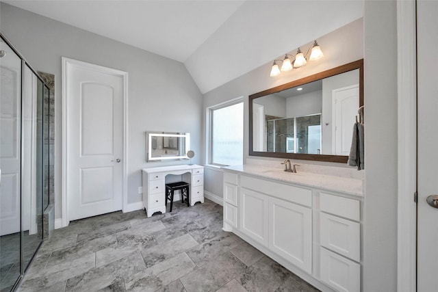 bathroom with vanity, vaulted ceiling, and walk in shower