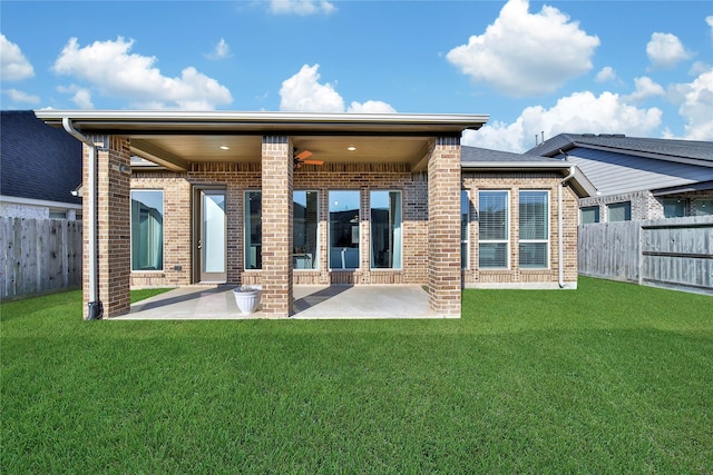 rear view of property with ceiling fan, a yard, and a patio