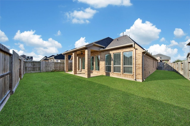 back of house with ceiling fan, a patio area, and a yard