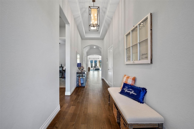 hallway with dark wood-type flooring and a high ceiling